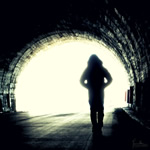 Someone walking away, alone, in through a tunnel